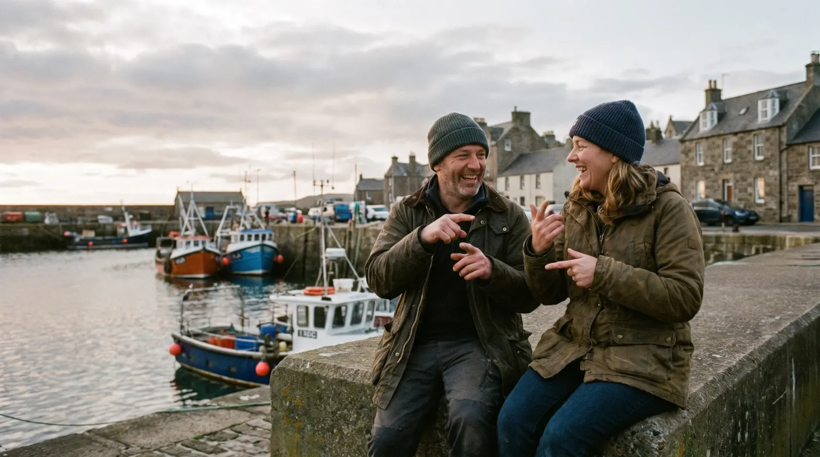A deaf couple chatting in British Sign Language on the harbour wall at Anstruther, Fife