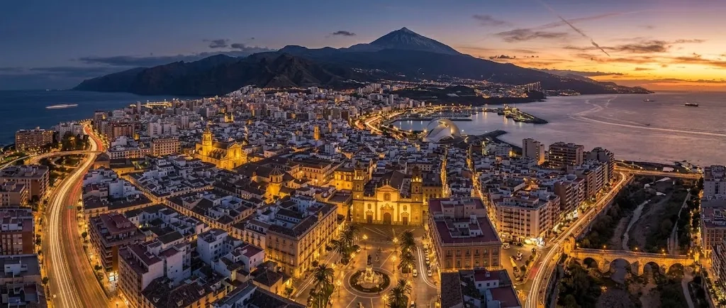 Vista aérea de Santa Cruz de Tenerife al atardecer, con el mar y el Teide al fondo