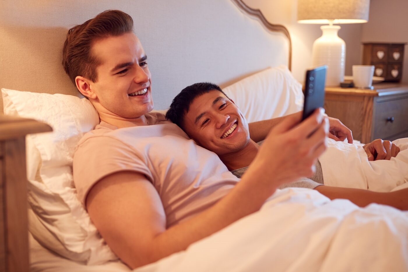 Two Gaydar members messaging each other from bed
