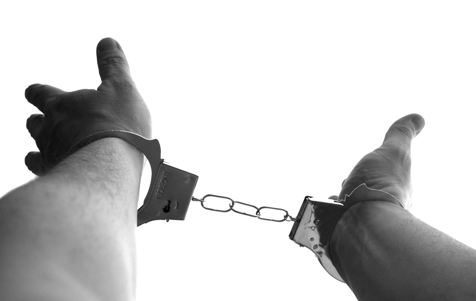 Two hands in handcuffs, black and white photo