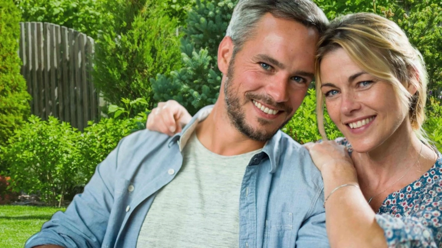 A smiling couple in their forties in a sunny garden