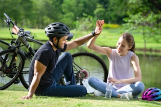 Couple sitting after a bike ride, giving each other a high five
