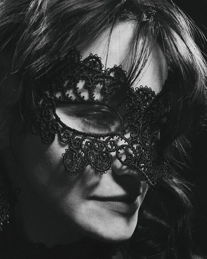 Woman wearing a black lace eye mask, black and white portrait