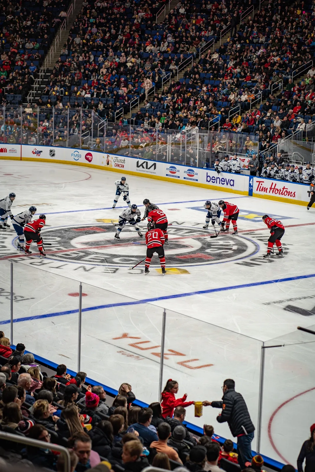 Packed arena seen from the upper stands during a faceoff