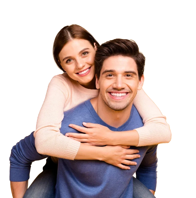 A smiling woman with her arms round a laughing man's shoulders, piggyback style