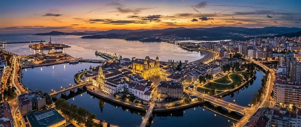 Vista aérea de Pontevedra al atardecer, con el casco histórico y el río Lérez iluminados