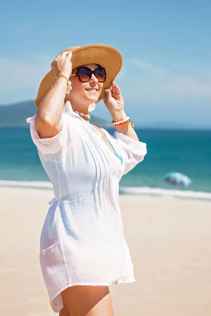 Mature woman in a sun hat by the beach