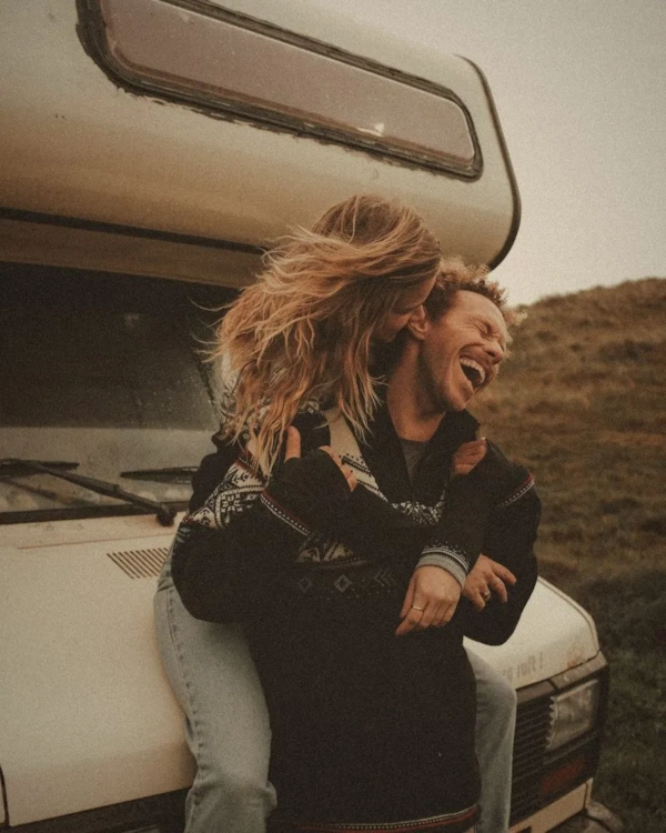 Couple laughing in front of a campervan