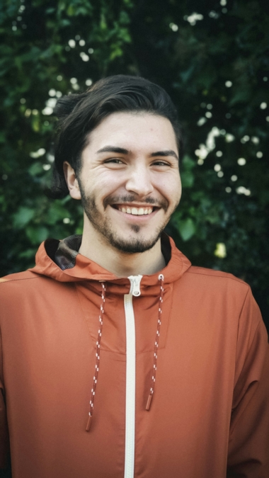 A man smiling naturally, at ease in an everyday setting
