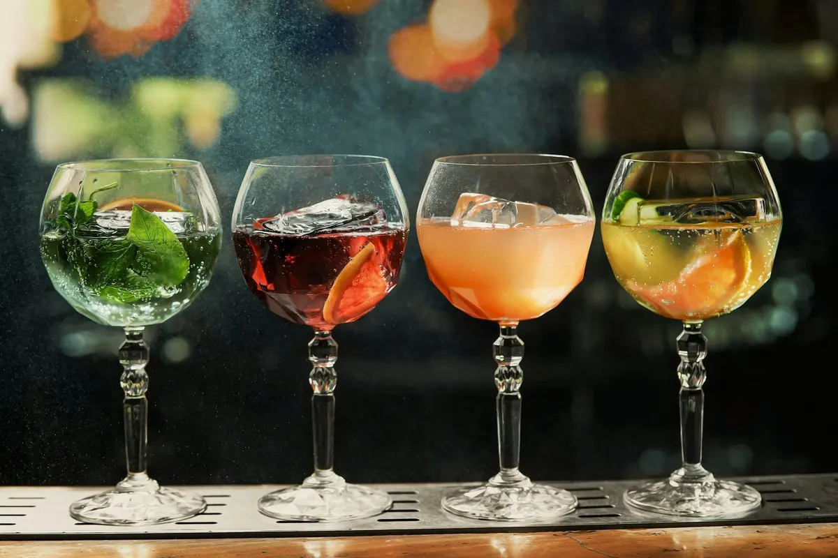 Four cocktails lined up on a bar counter