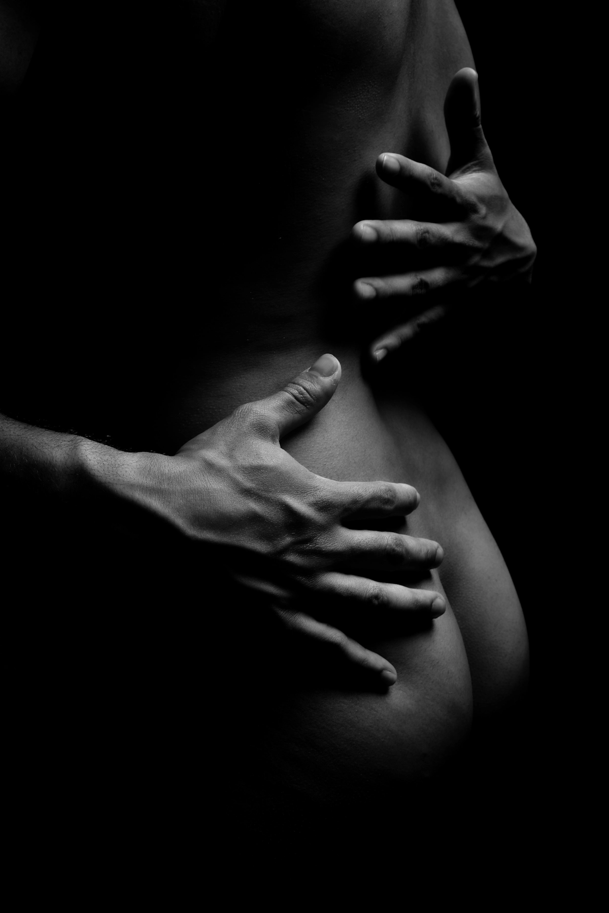 Primer plano en blanco y negro, manos sobre el cuerpo.