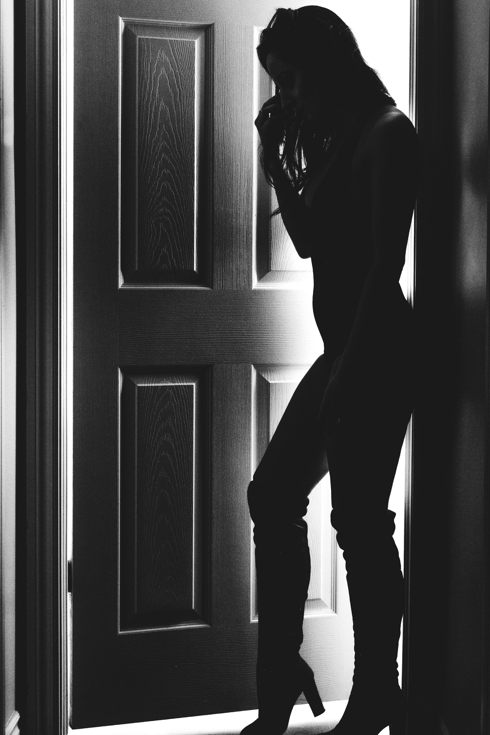 Silueta en blanco y negro junto a una puerta entreabierta