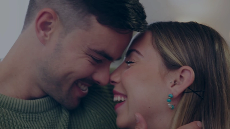 A couple laughing together, foreheads touching