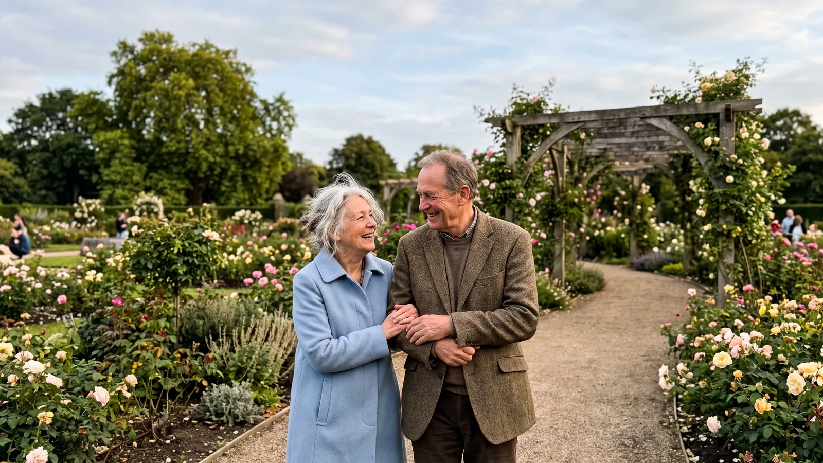 A couple in their late sixties walk arm in arm along a curving path through a rose garden with a pergola in a London park, smiling at each other (AI-generated image)