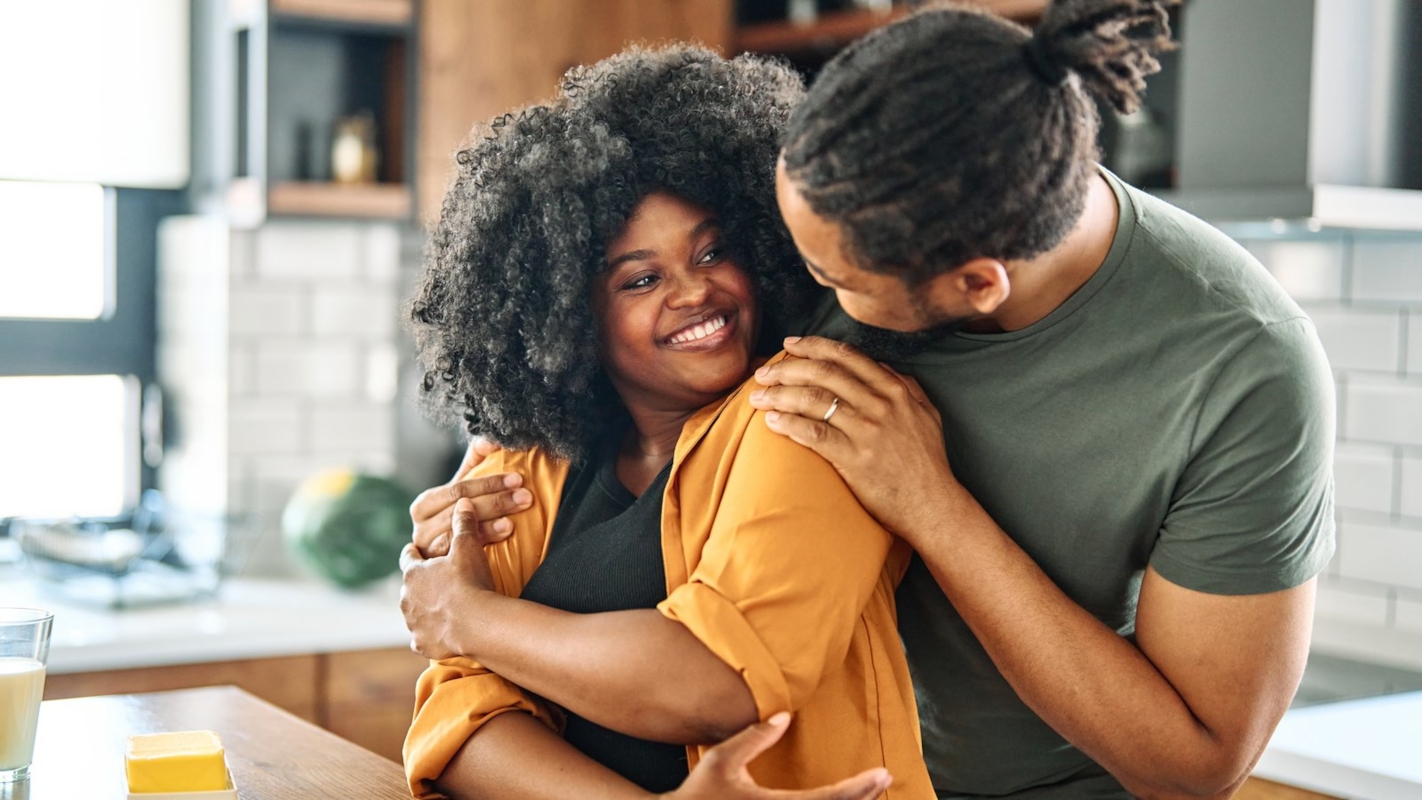 A couple embracing warmly in their kitchen at home