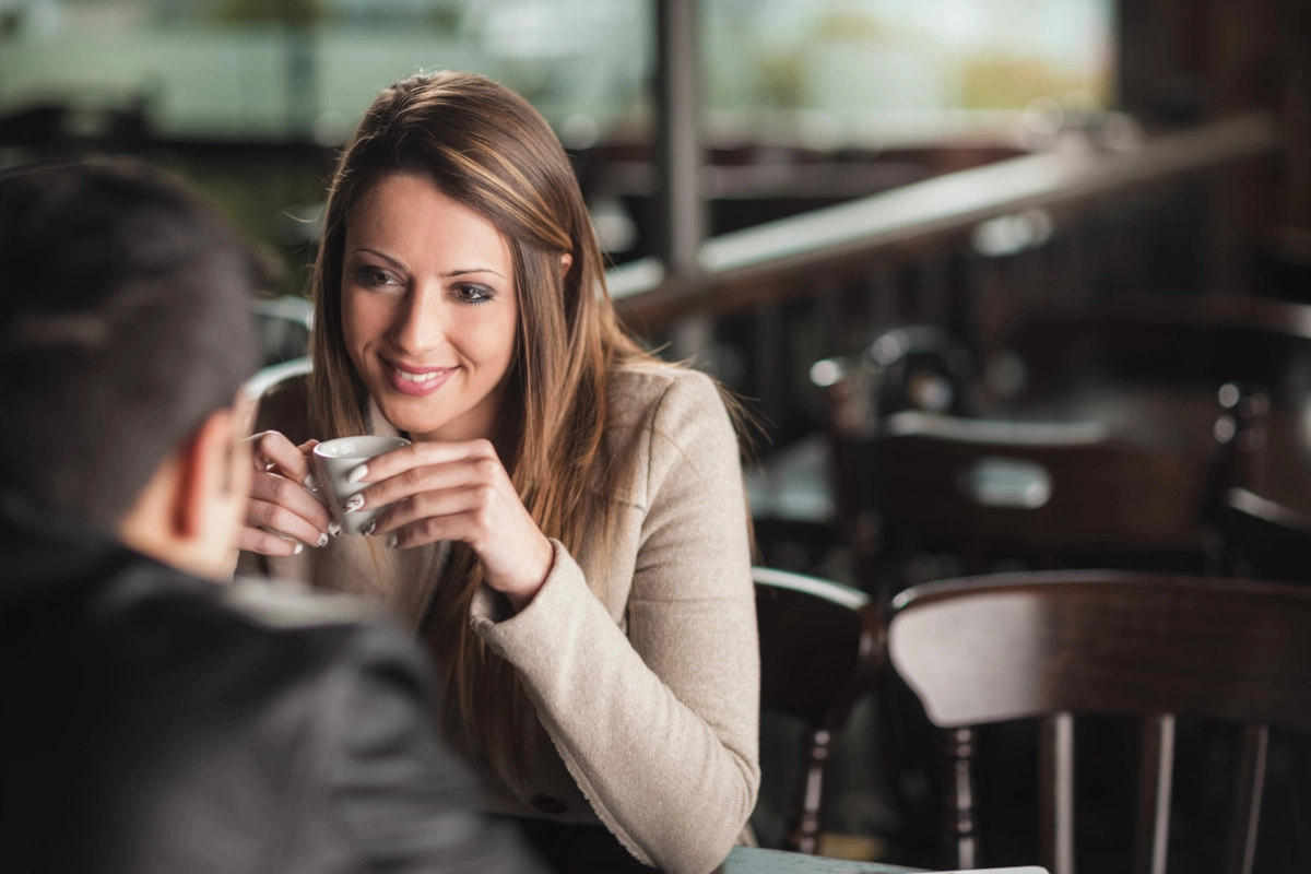 Two people talking and laughing over coffee on a first date