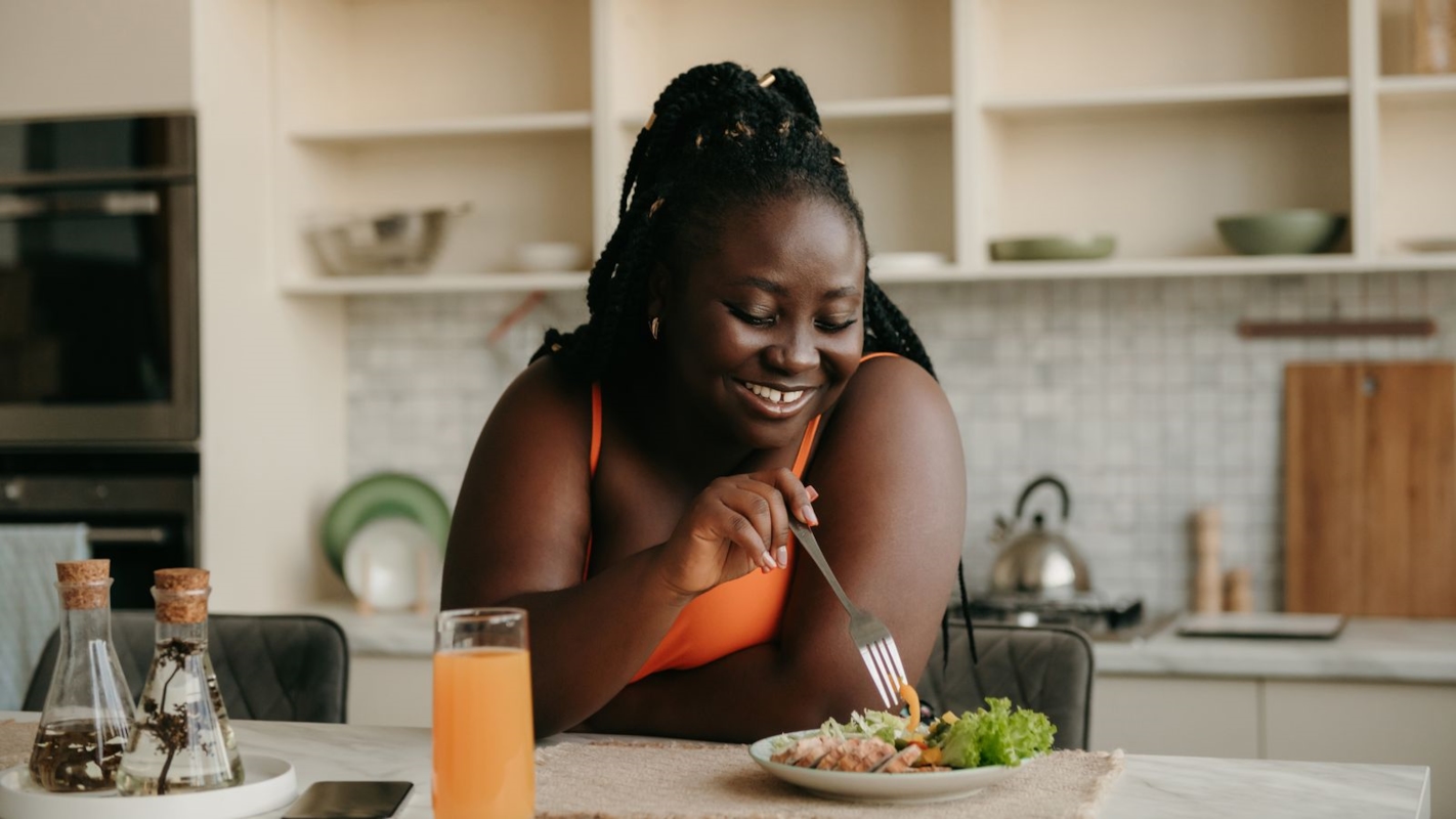 A woman enjoying breakfast at home in the morning light