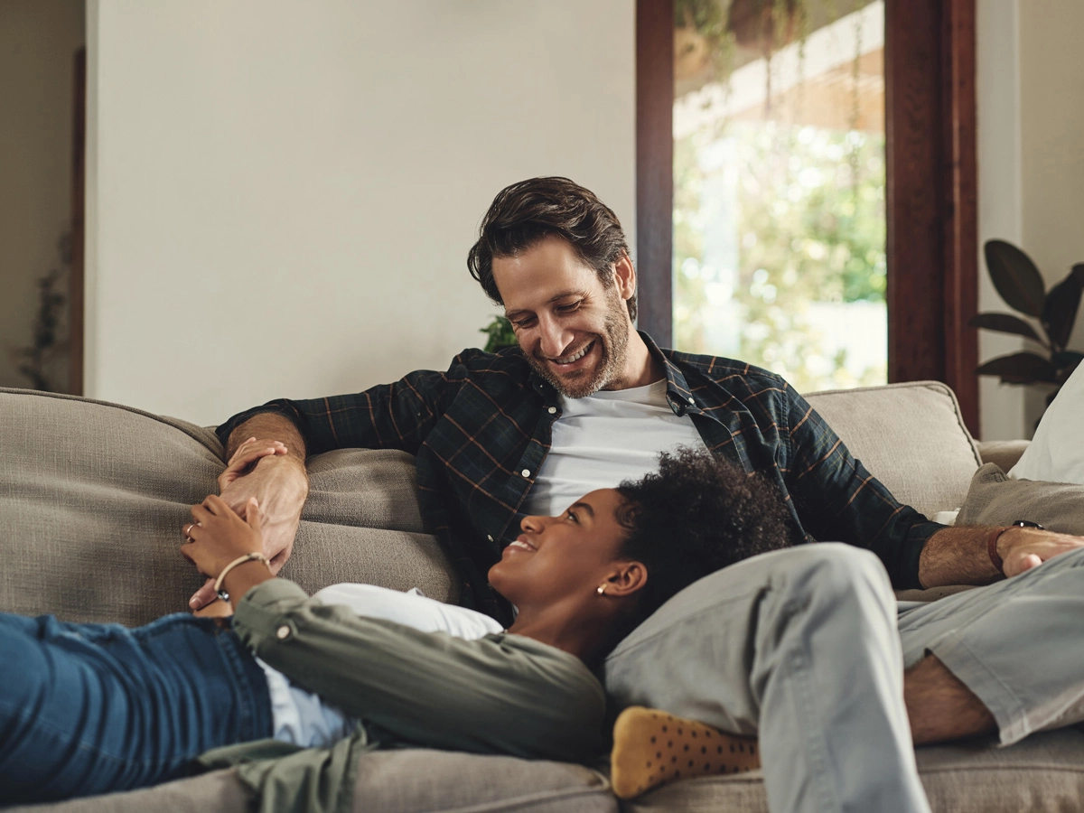 Mixed race couple laughing together in the kitchen