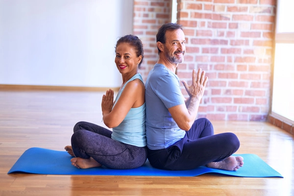 Two people practicing partner yoga pose
