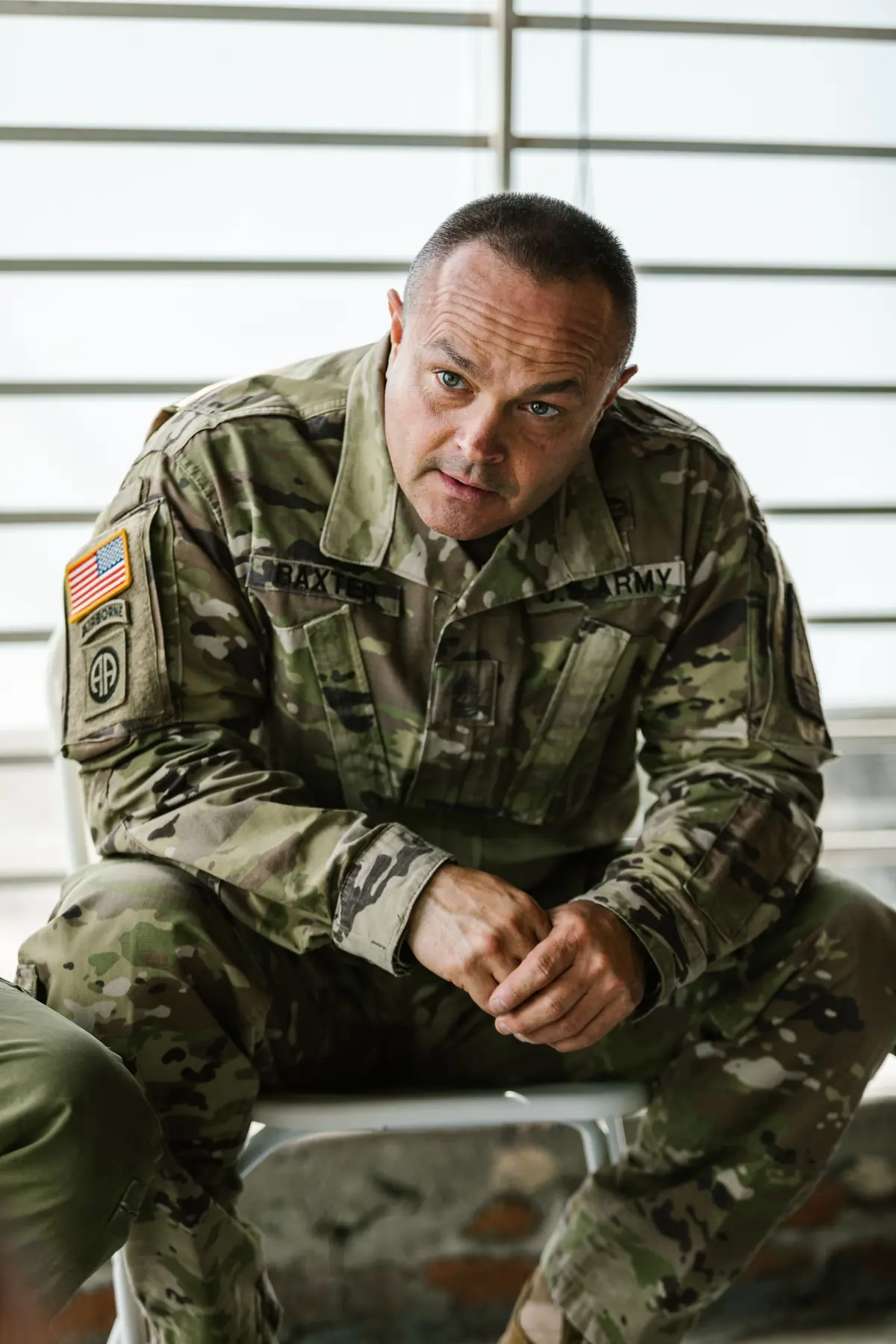 Illustrative portrait of a uniformed adult reflecting while seated