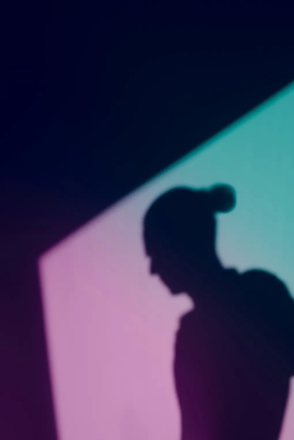 La sombra de una persona proyectada sobre una pared iluminada.