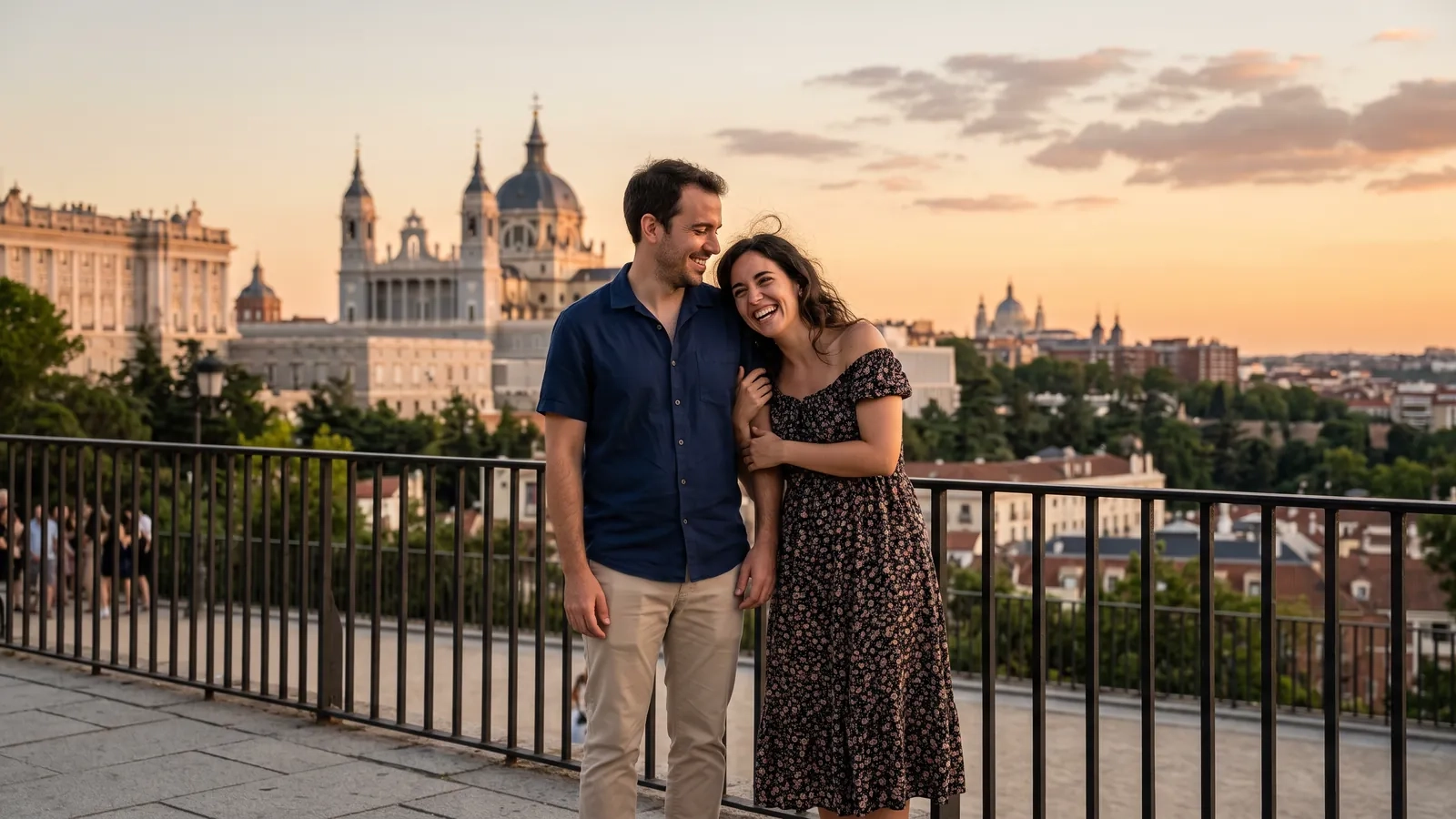Una pareja abrazada en la barandilla de las Vistillas al atardecer, con la catedral de la Almudena y el Palacio Real al fondo (imagen generada por IA)