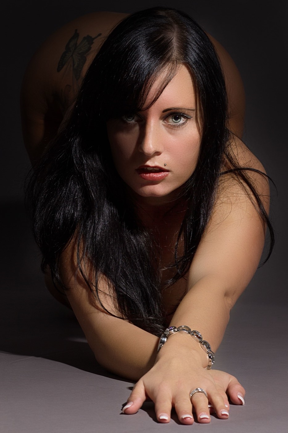 Illustrative stock photo of a woman with long dark hair leaning toward the camera with an intense gaze. Does not depict real members.