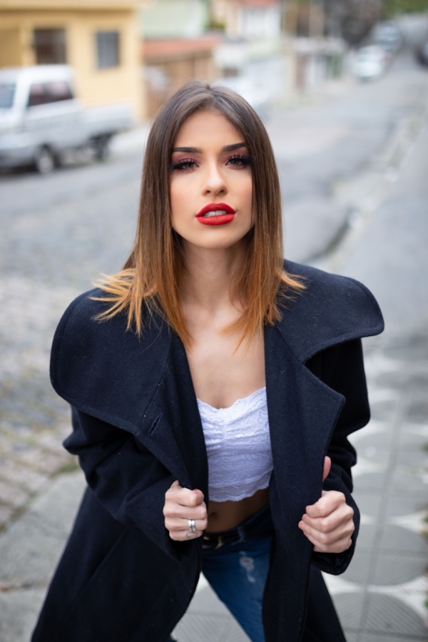 Illustrative stock photo of a woman on a city sidewalk in a dark coat. Does not depict real members.\