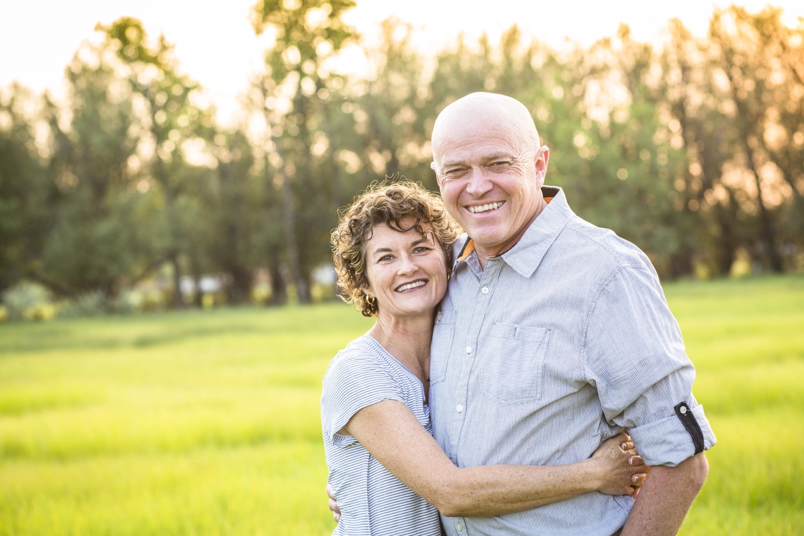 A smiling mature couple embracing outdoors