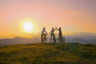 Cycling group celebrating together with high fives after a tough ride