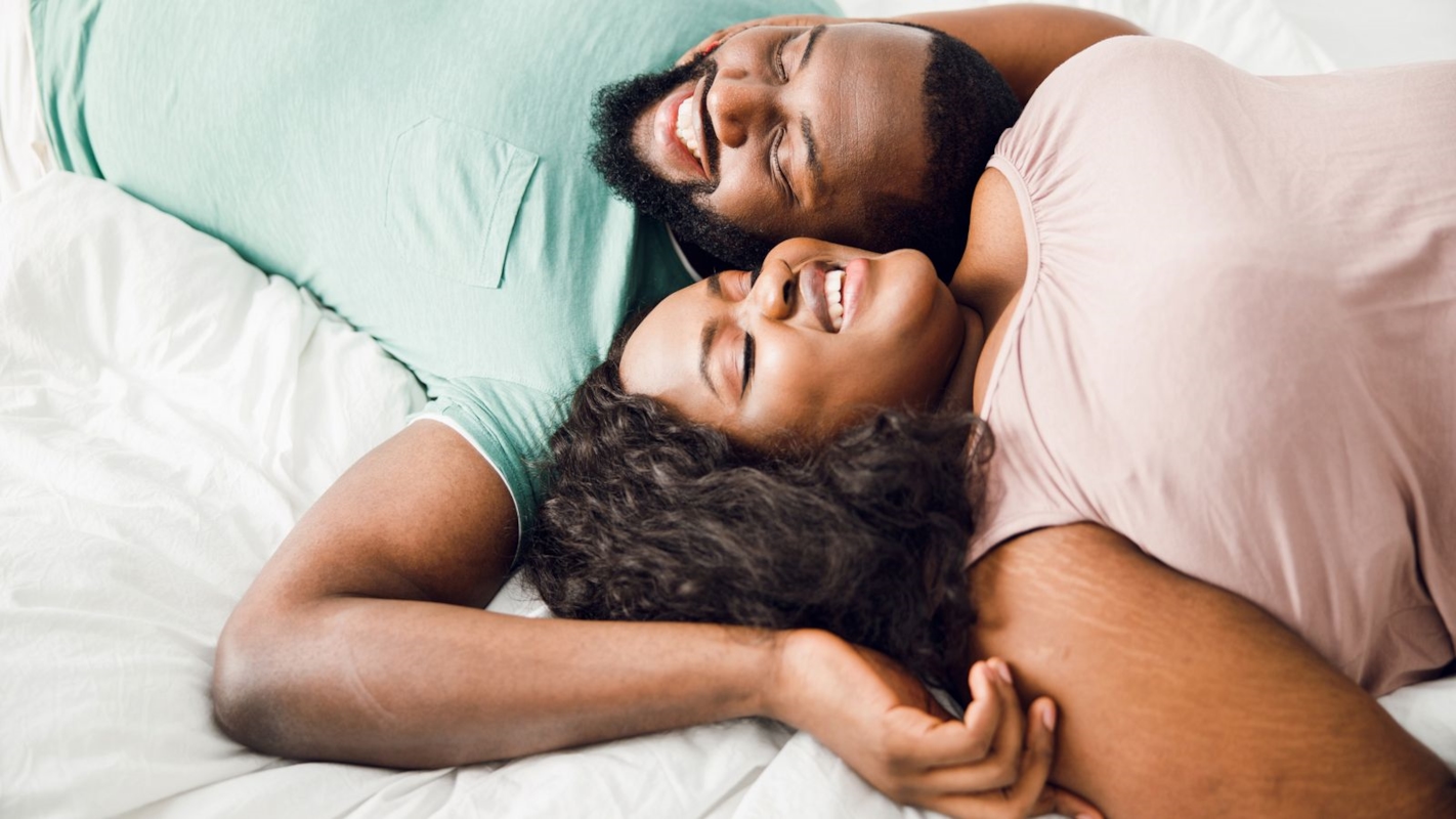A couple laughing together, foreheads pressed close in a tender moment