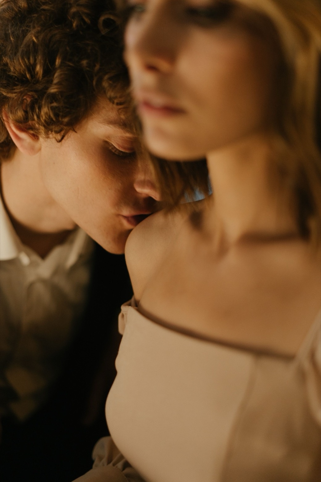 Illustrative stock photo of an adult kissing another adult on the shoulder. Does not depict real members.