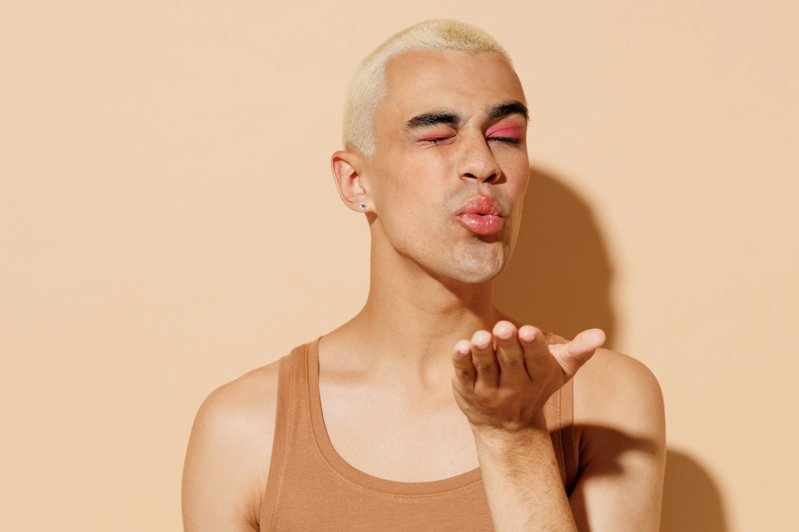 Un hombre lanzando un beso a cámara.