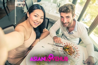Happy couple meeting in person at a stylish café, representing Asian Love Hub luxury dating.