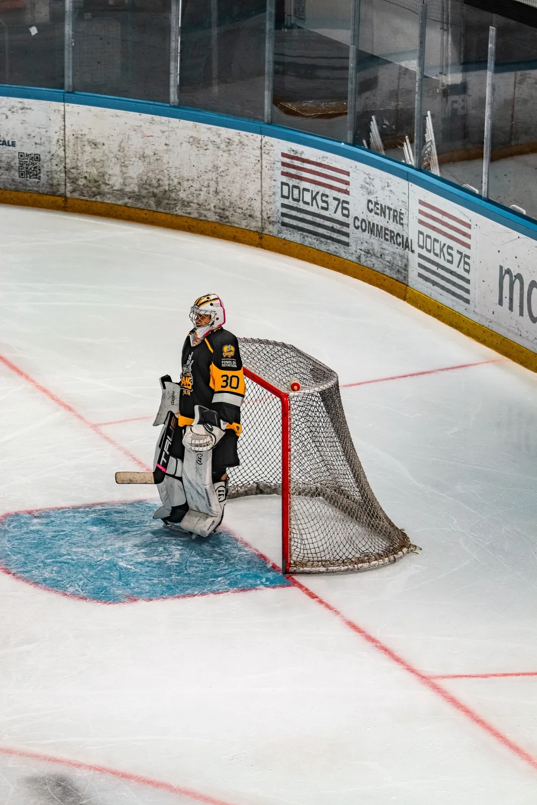 A goalie crouched and ready in front of the net