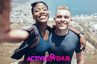 A happy couple in athletic gear posing for a selfie while jogging along the mountains.