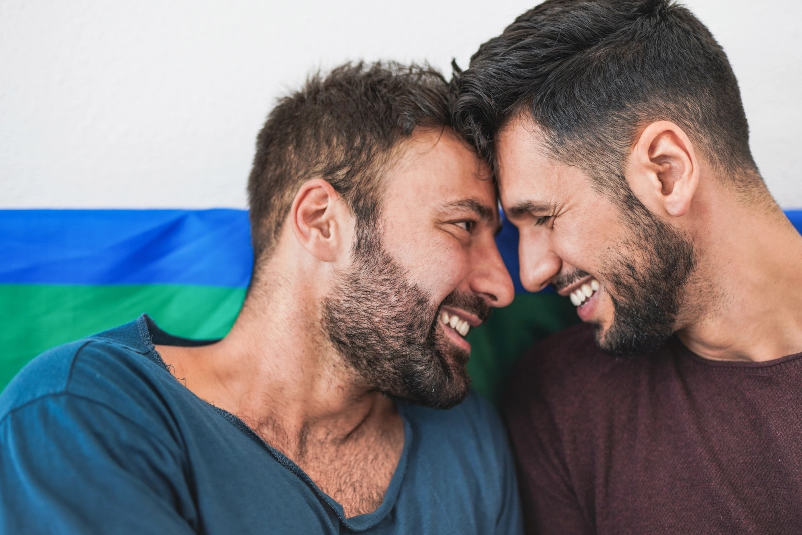 Dos hombres muy juntos, sonriendo.