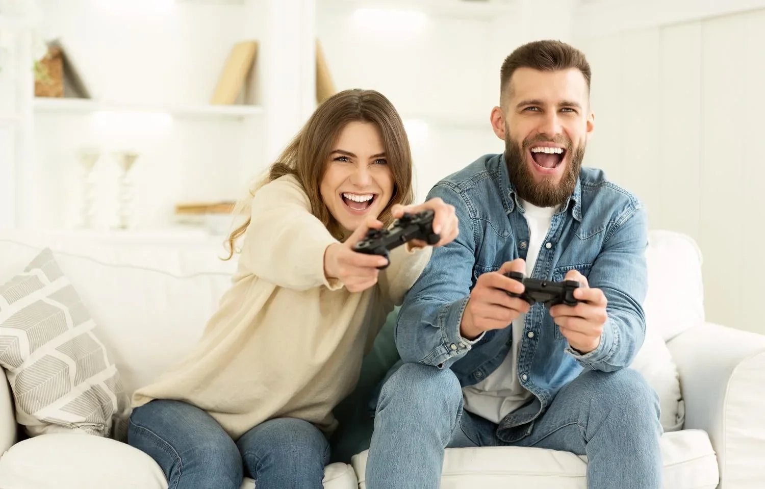 Happy couple playing video games together on a sofa