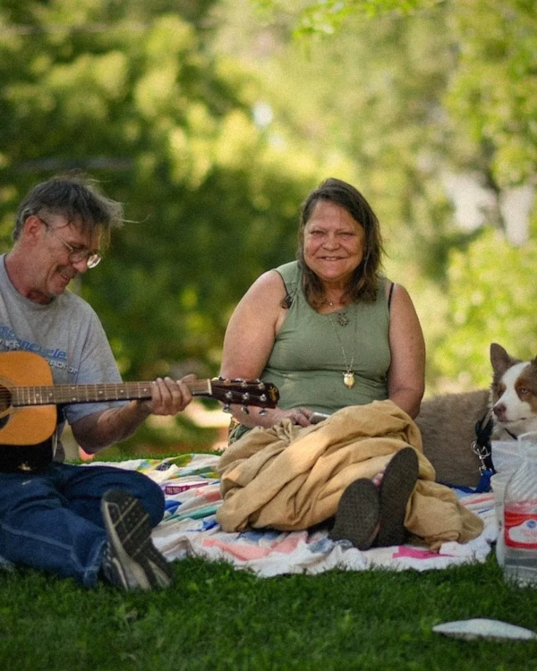 Man and woman with a guitar on a picnic blanket