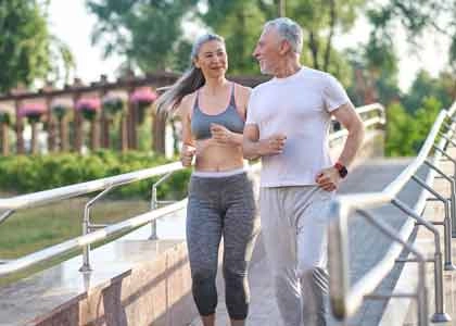A mature couple running together outdoors