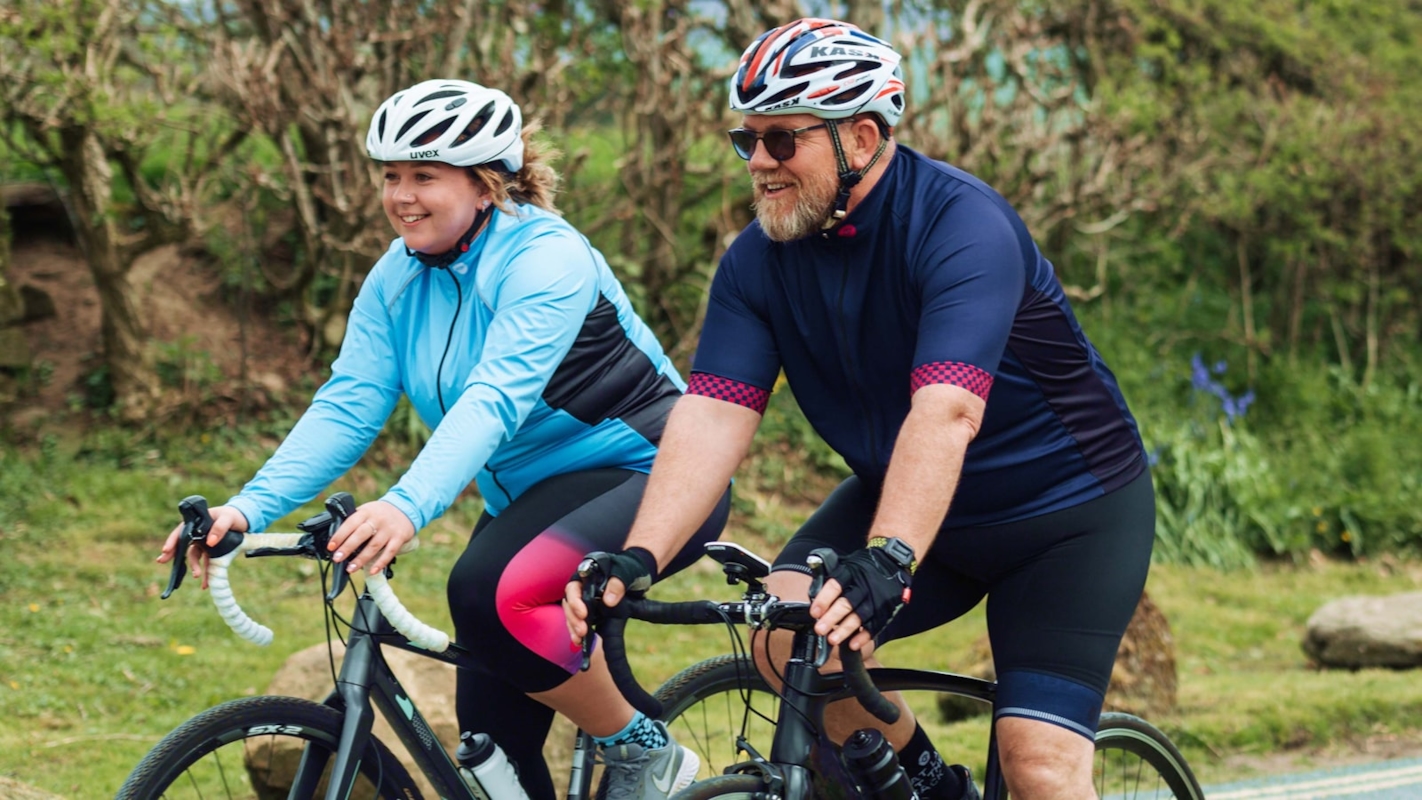 A couple smiling together while riding bikes outdoors