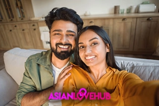 Happy couple relaxing on a sofa after meeting on Asian Love Hub luxury dating app.