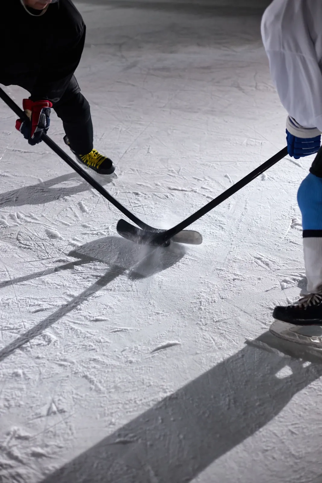 Hockey sticks and skates lying on fresh ice