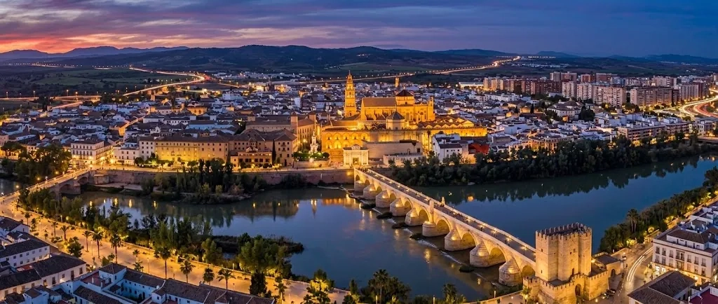 Vista aérea de Córdoba de noche con la Mezquita-Catedral y el puente romano