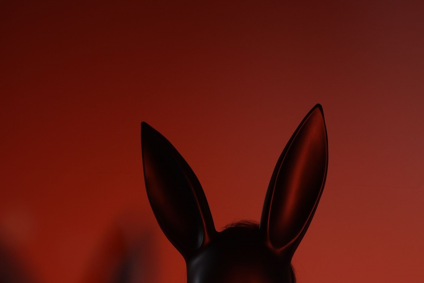 Femme avec masque de lapin sous une lumière rouge