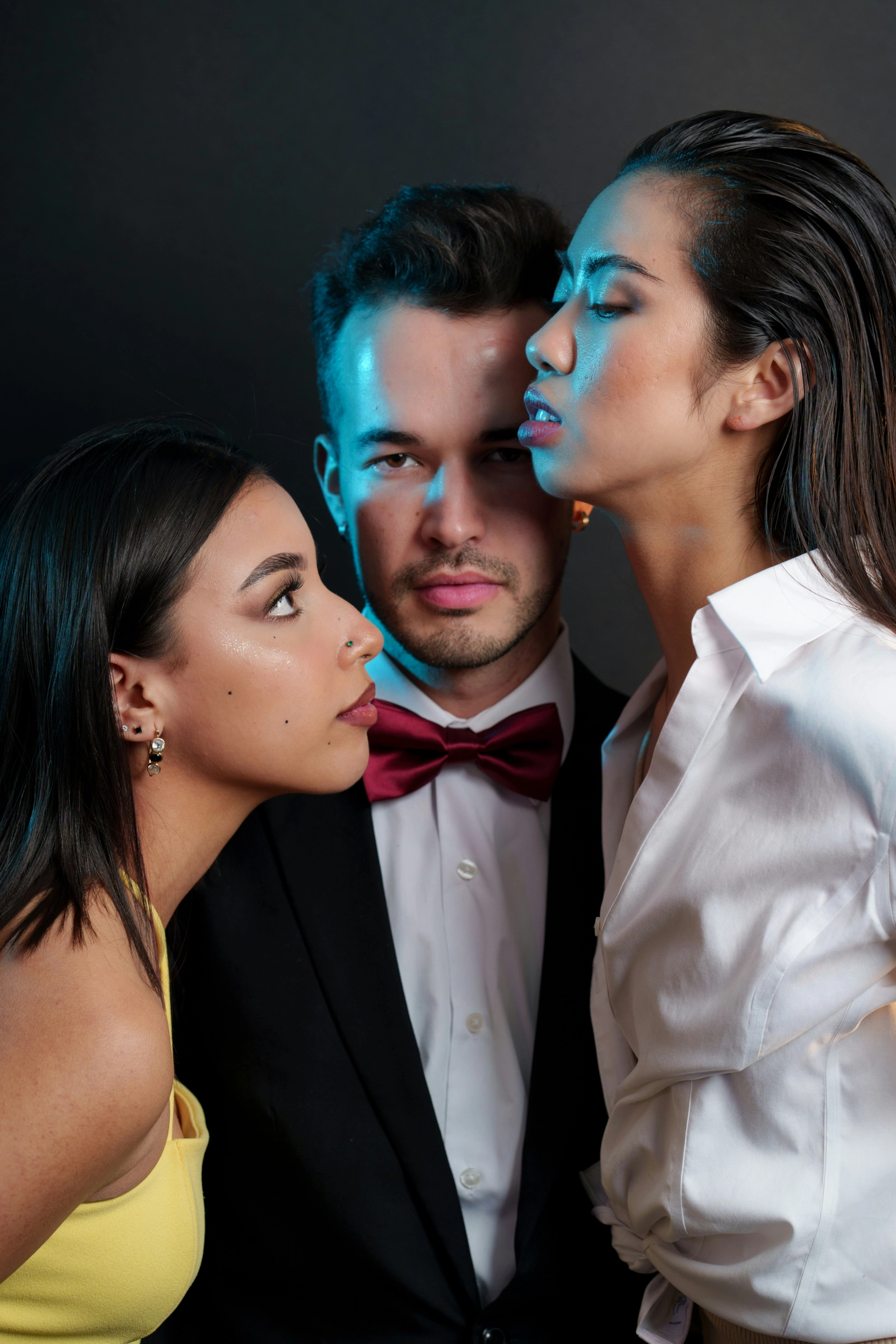 Tres personas muy cerca, en un retrato de estudio con luz de color