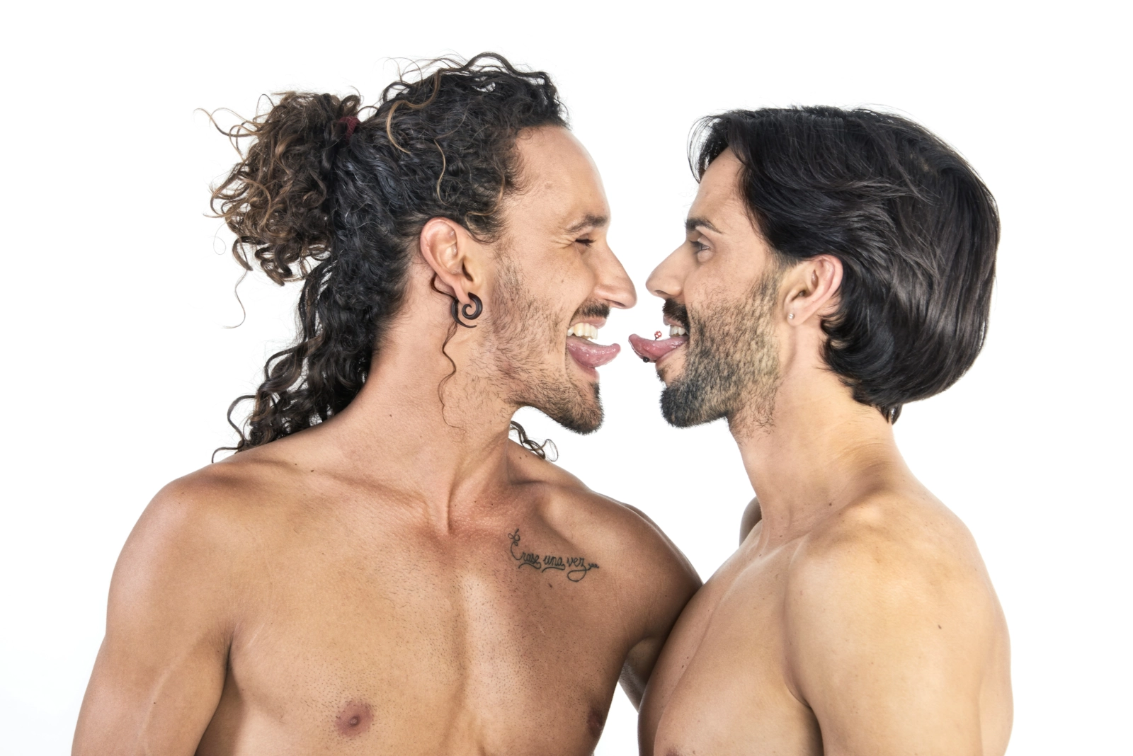 Dos hombres de cara, riéndose muy juntos.