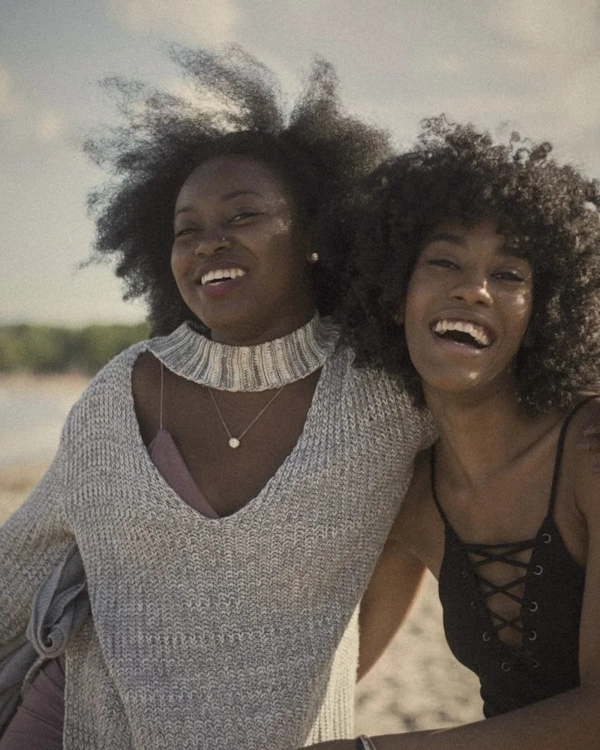 Two women laughing together by the sea