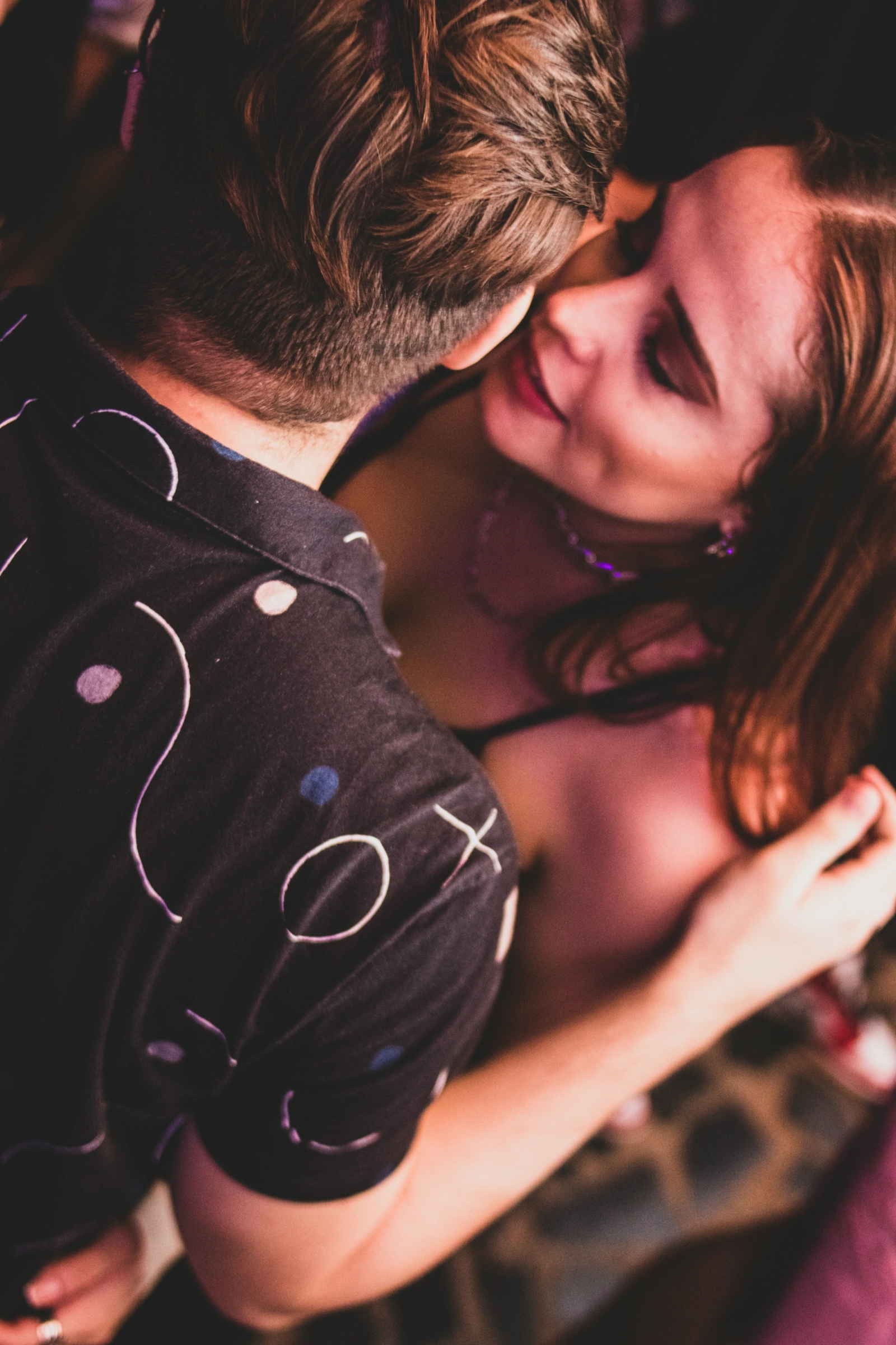 Pareja bailando cerca, luz cálida de boliche