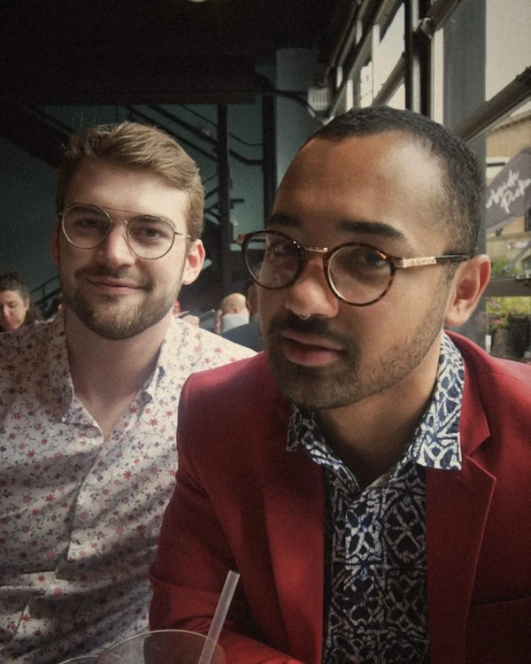Two smiling men in glasses at a party